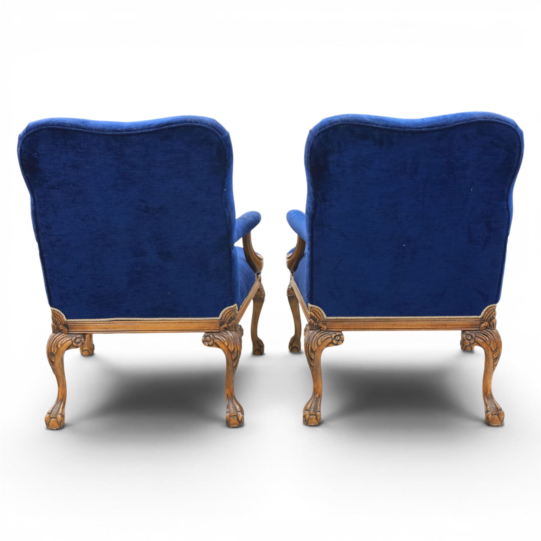 Pair of George II design Gainsborough armchairs in deep blue upholstery, shaped back over scrolled and carved arms, with cabriole supports and carved shell knees terminating in claw on ball feet