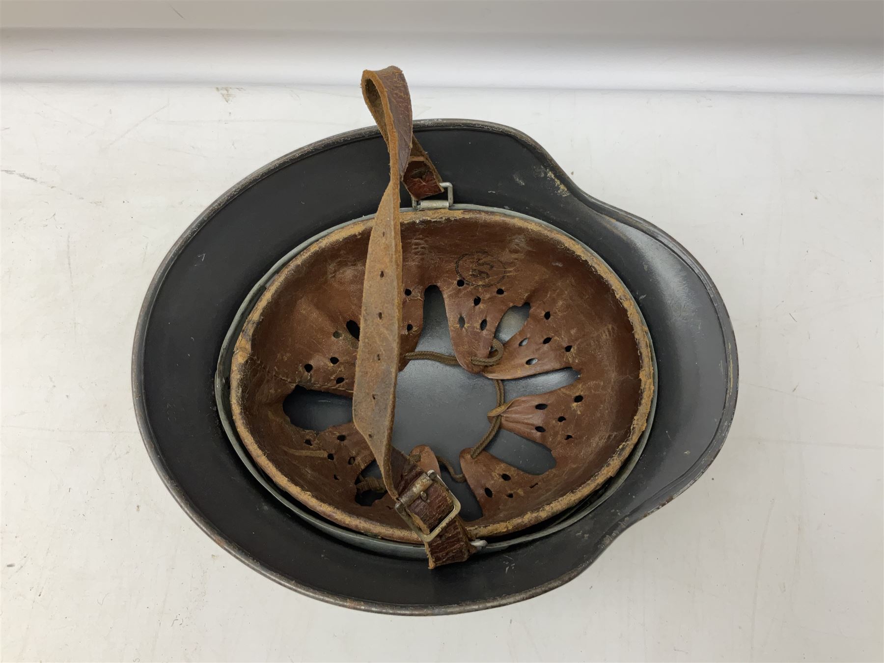 WW2 German steel helmet painted in undecaled Luftwaffe bluey grey with leather liner and chin strap stamped '58', the skirt impressed '1250'