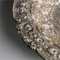 Late 19th/early 20th century continental silver serving bowl, of oval form, profusely embossed with scrolling floral and foliate decoration, with hammered finish to interior