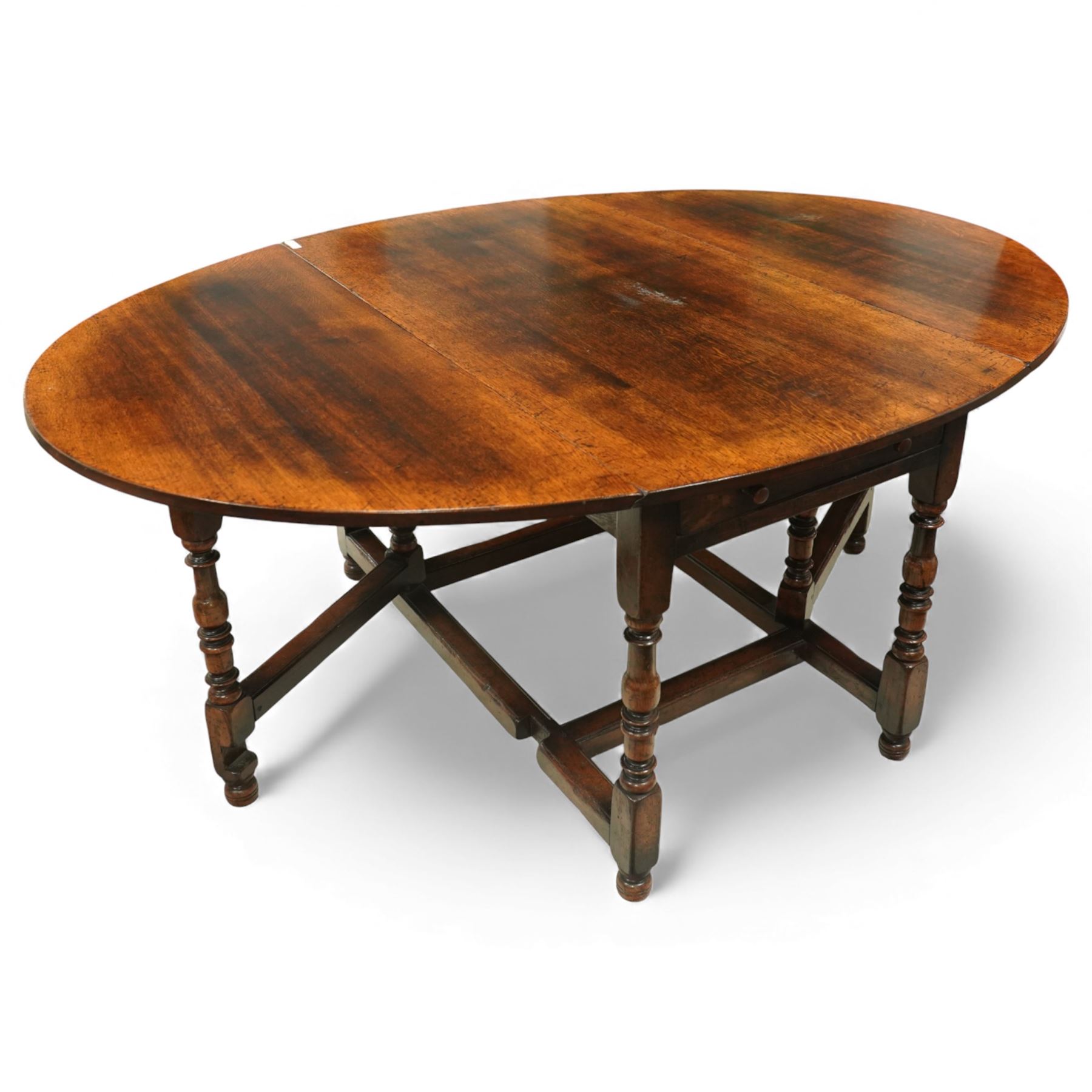 Large 18th century design oak drop-leaf dining table, oval top with twin hinged drop leaves, drawers to either end, raised on turned supports united by an H-stretcher base