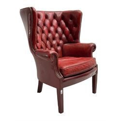 Georgian design barrel wingback armchair, upholstered in buttoned leather with studwork 