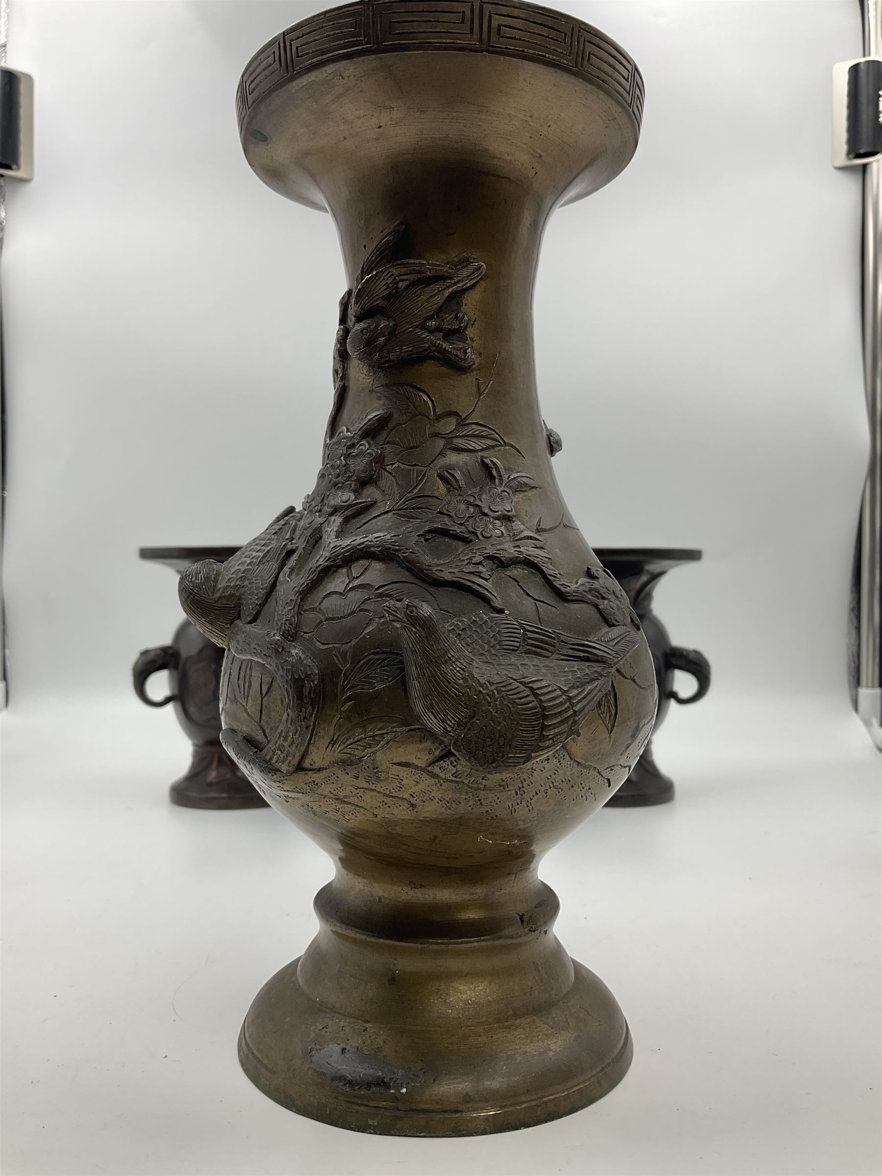 Chinese bronze vase, of baluster form with elongated neck, decorated in relief with birds amongst prunus blossom, together with a smaller pair of twin handled bronzed vases, decorated with peacocks and a blue Peking glass dish, with white metal mounted decorated with dragons, bronze vase H23.3cm
