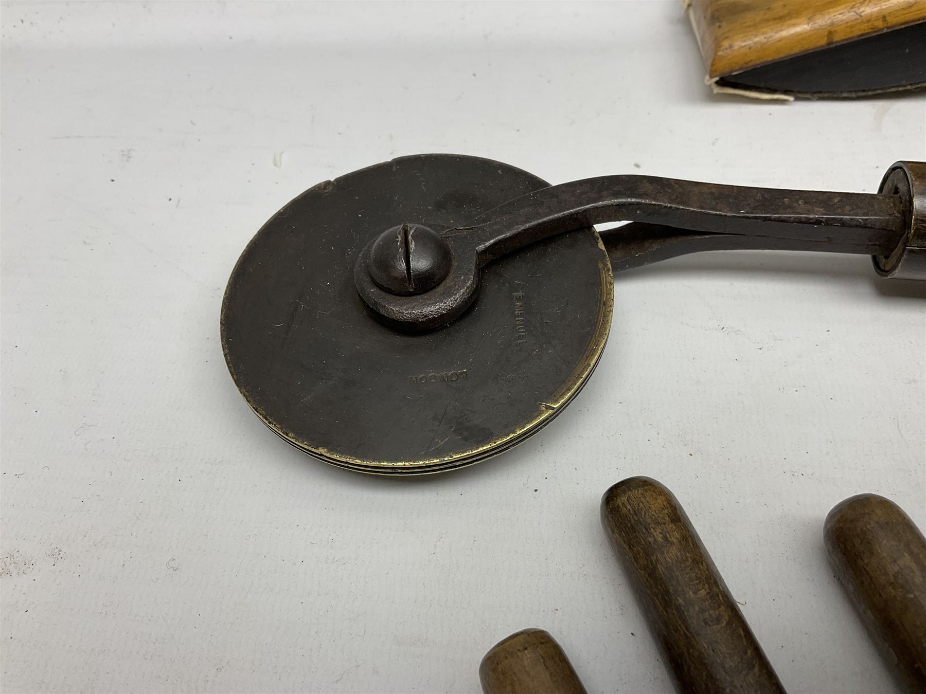 Thirty-one bookbinder's brass number and letter stamps, predominantly with beech handles, together with a bookbinder' decorative fillet roll, with brass triple line wheel stamped E. Menuel London, with wood handle, and two ink blotters