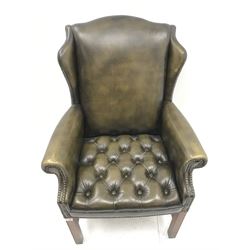 Georgian style wing back armchair upholstered in deep buttoned and studded green leather, square supports