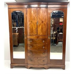 Edwardian inlaid mahogany triple wardrobe, bow front centre with two cupboards above four graduating drawers flanked by two bevel edged mirror doors, shaped platform base 