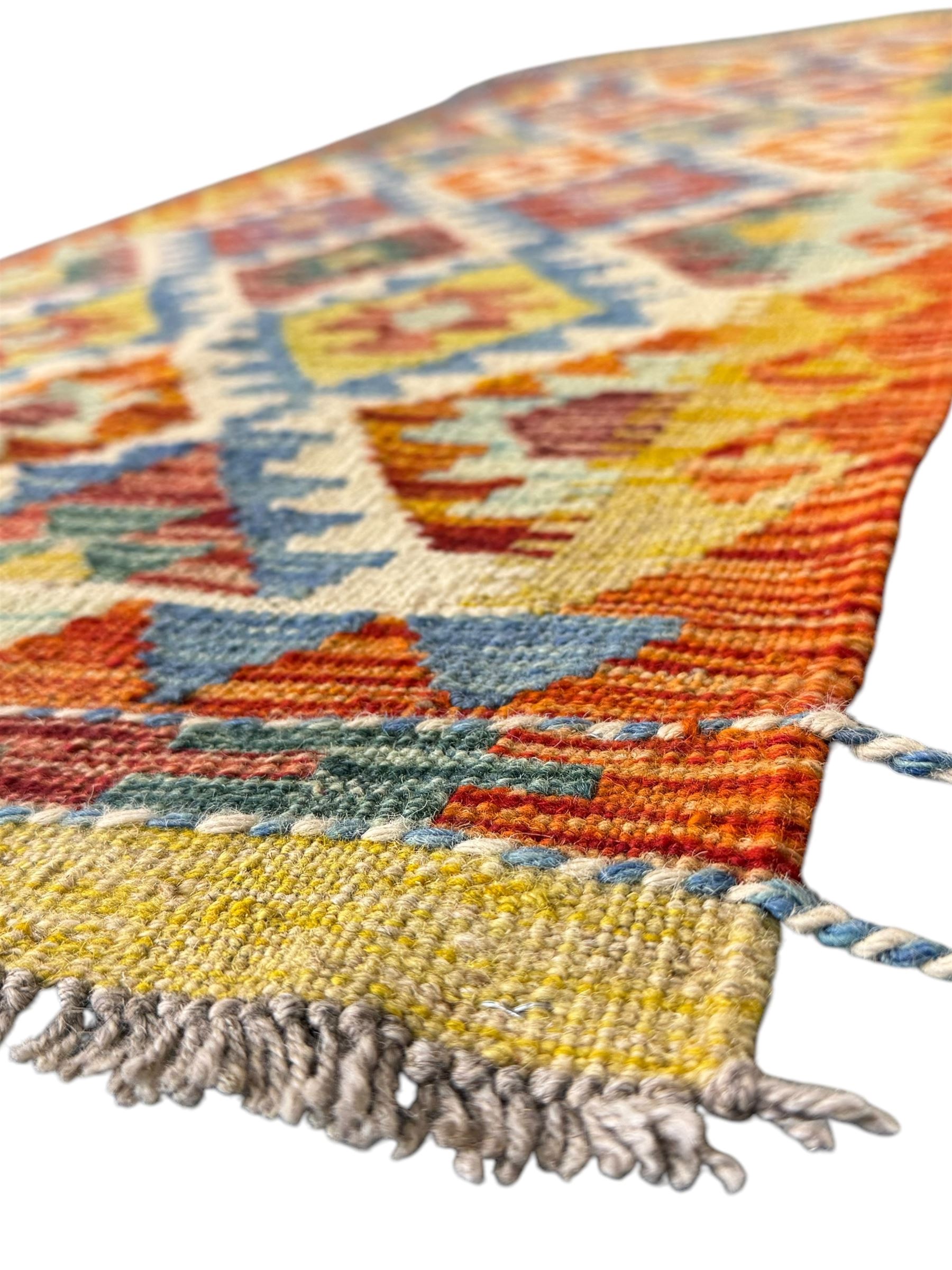 Chobi Kilim runner, cream ground with a multicoloured lattice of repeating diamond motifs, framed by a geometric border, finished with braided corner tassels