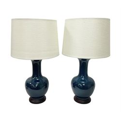 Pair of Chinese teal glazed table lamps, each of bottle form, raised upon circular hardwood base, excluding fittings H43cm