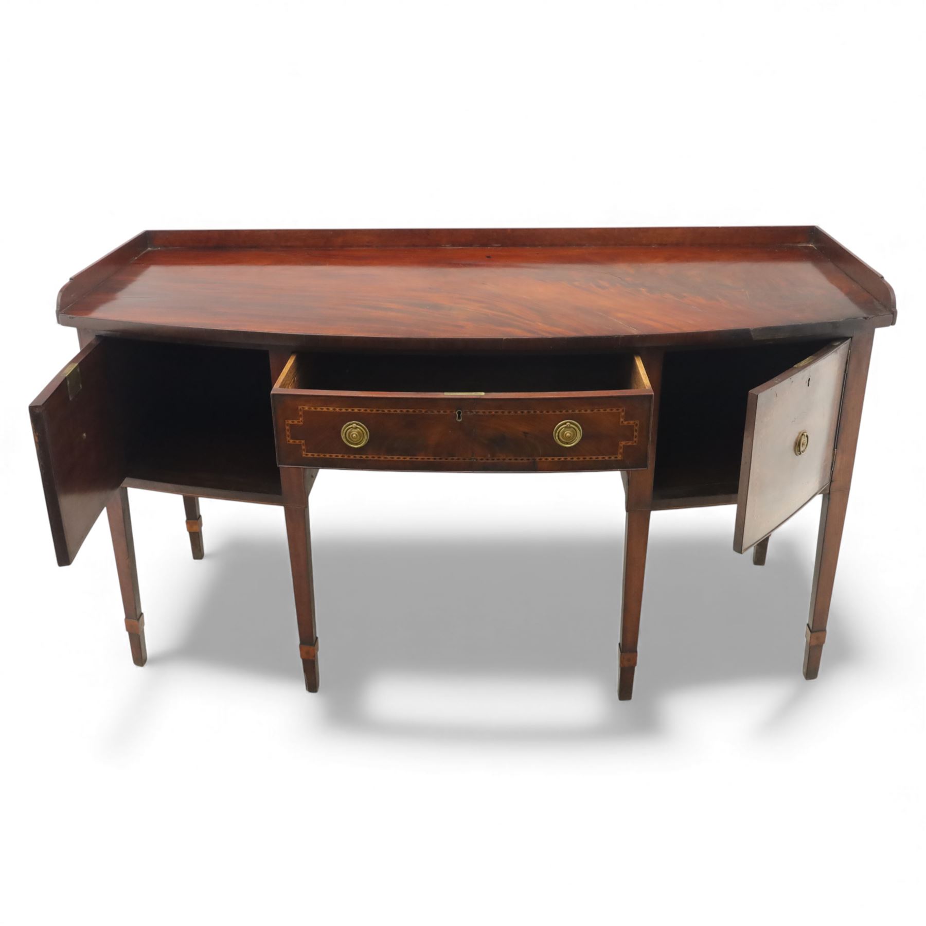  George III mahogany bow-front sideboard, the top with shaped gallery back above one frieze drawers, each outlined with strung inlay, flanked by deep cupboard doors, raised on square tapering legs with spade feet