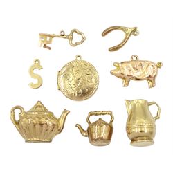 Eight 9ct gold pendant / charms including pig, locket, kettle and jug