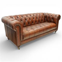 Ullswater - late 20th century brown leather chesterfield sofa, deep button tufted back, arms and seat, classic rolled arm form with studded borders to the arms and base, raised on turned feet with castors