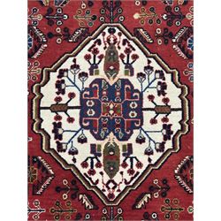 Fine Persian Qashqai crimson and navy ground runner, three large medallions filled with geometric and floral designs, the field with angular vines and stylised floral decoration, wide ivory border decorated with repeating floral and angular motifs