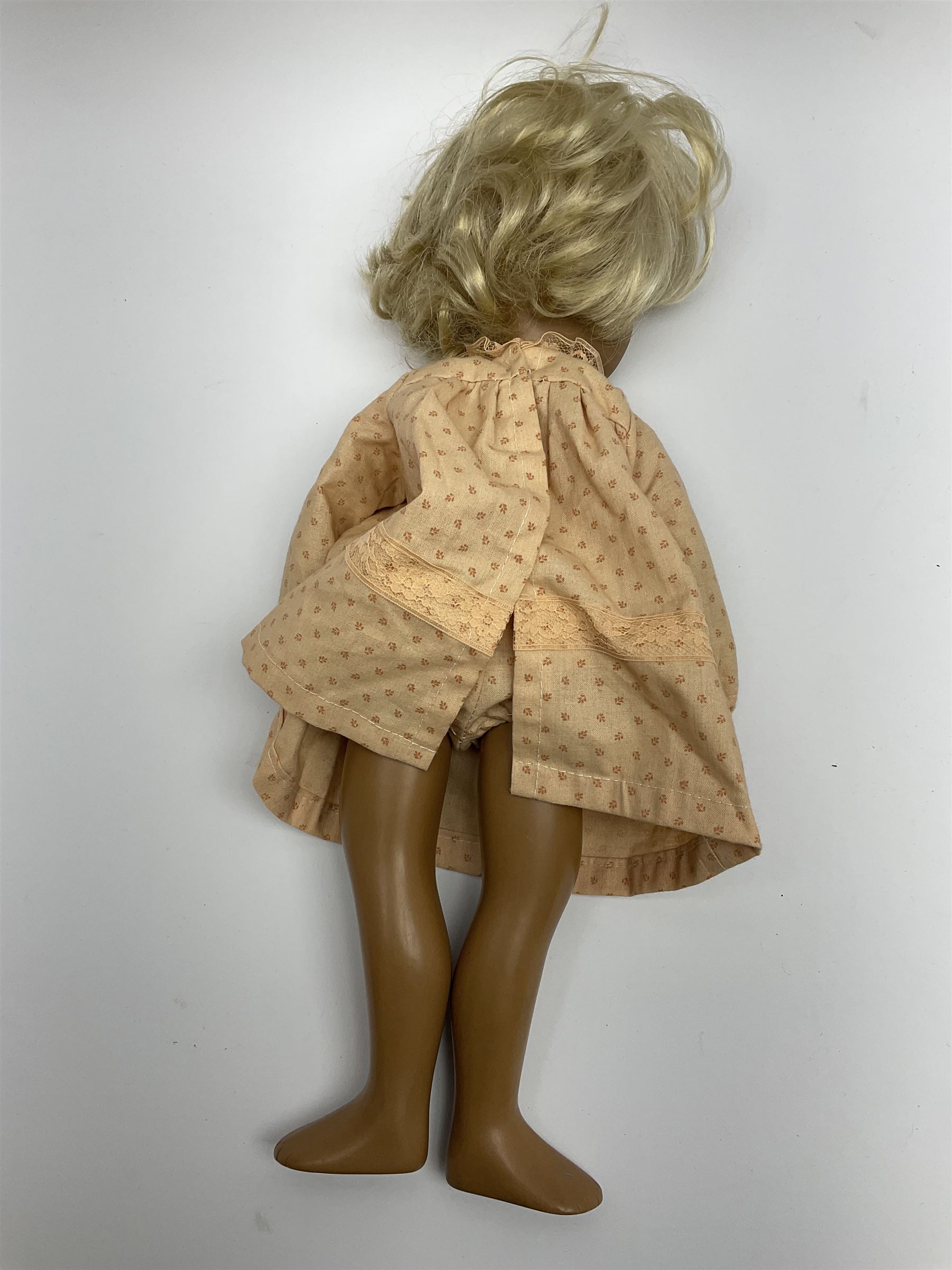 Sasha Morgenthaler vinyl doll, the girl's head with painted blue eyes and lips and short blonde hair, the jointed body donning a peach floral dress with matching underclothes, unmarked, H41cm