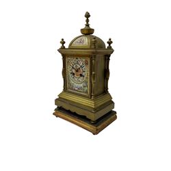 French - late 19th century 8-day mantle clock in a satin gilt brass case, with a rectangular porcelain panel to the front incorporating cartouche Roman numerals and a depiction of two lovers, cupid, and musical instruments,
Eight-day movement striking the hours on a bell, case standing on a gesso padded plinth.
