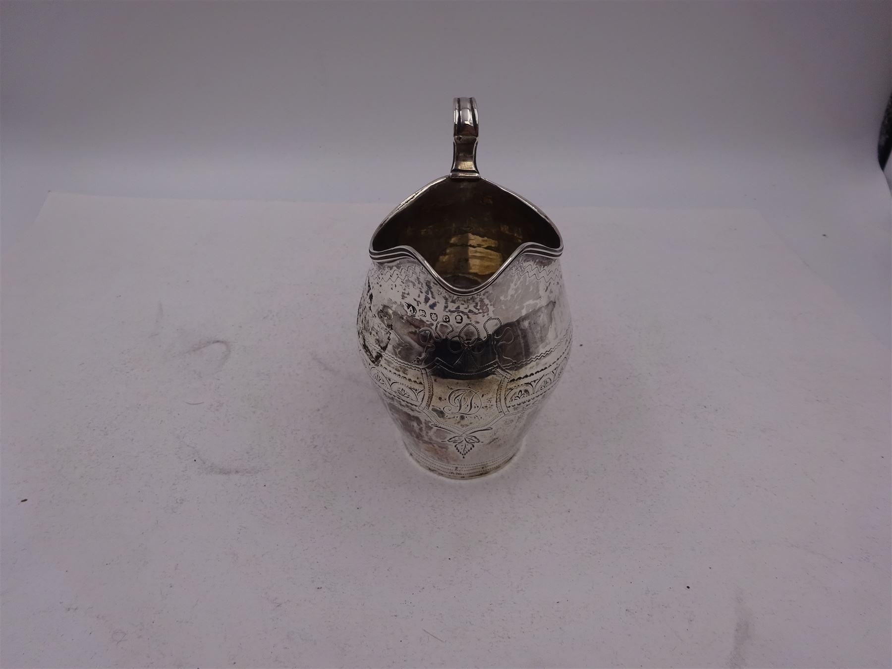 George III silver cream jug, of helmet form, with C scroll handle and a band of engraved strapwork decoration and monogrammed initials to body, hallmarked London 1802, maker's mark SA probably Stephen Adams I, including handle H10.4cm