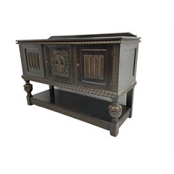 Late 19th/early 20th century Baroque Revival oak buffet sideboard, moulded rectangular top over gadroon moulding, enclosed by three panelled doors, the central door carved with female mask, c-scrolls and trailing foliate, the two flanking doors with linen fold panels, on lobe carved baluster supports joined by undertier with lunette rail