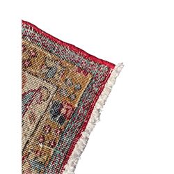 Persian Tabriz crimson ground rug, the field decorated with large palmette and stylised plant motifs connected by interlaced leafy branches, trailing border decorated with similar palmette motifs within floral pattern guard stripes, with signature panel 