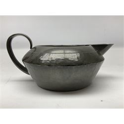 Liberty & Co Tudric pewter three piece tea service, comprising teapot with woven reed handle, twin handled open sucrier, and milk jug, each of squat form with planished finish, each impressed beneath Tudric Pewter Ware 01537 Made in England, together with a matched unmarked tray
