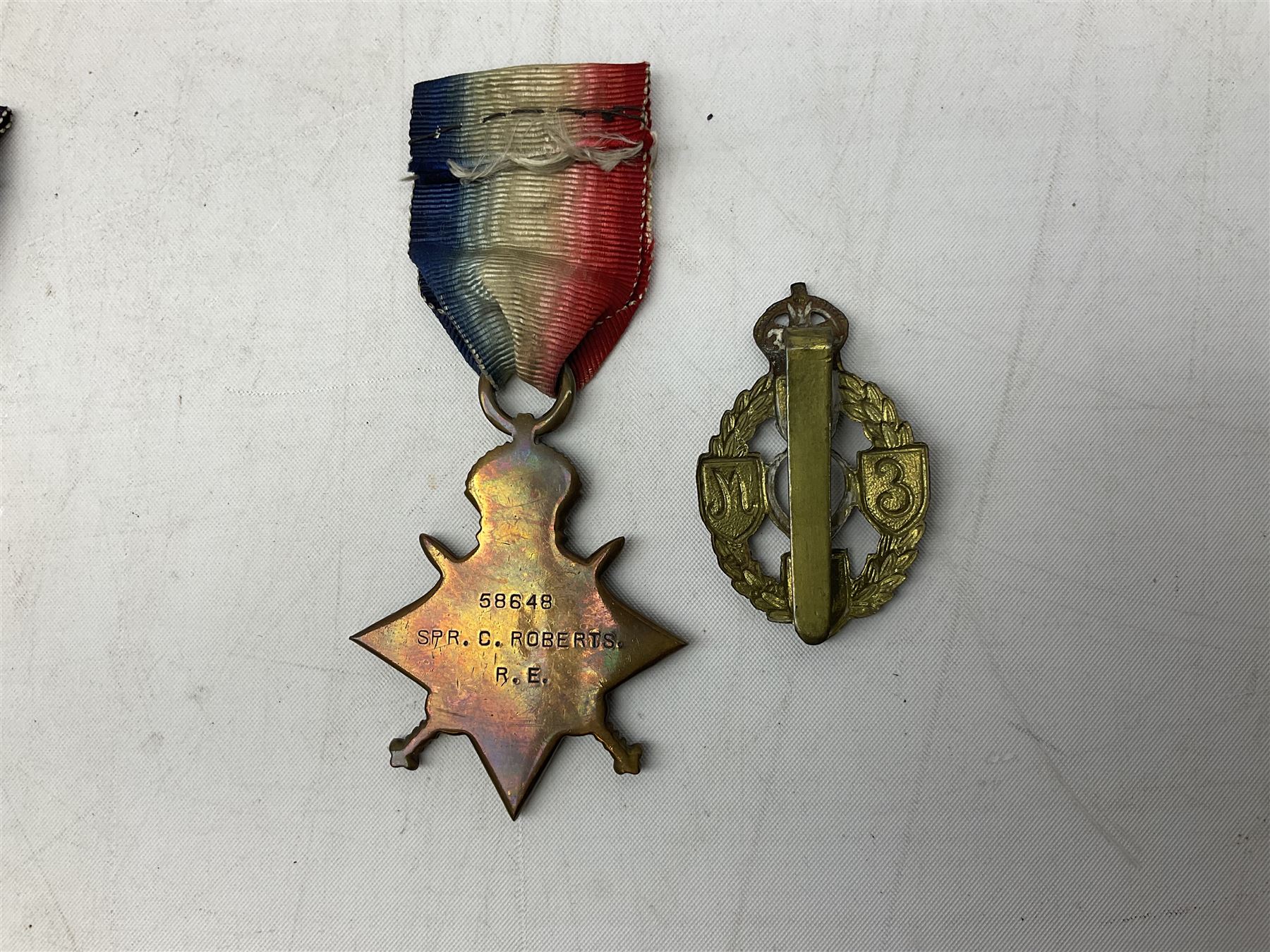 Three WW1 medals comprising 1914-15 Star awarded to 58648 Spr. C. Roberts R.E.; British War Medal and Victory Medal awarded to 87502 1.A.M. C. Roberts R.F.C.; and REME cap badge (4)