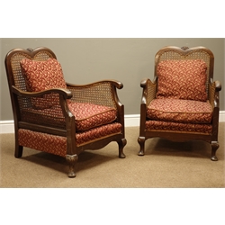  Early 20th century walnut framed three piece bergere suite, two seat settee (W123cm, D71cm), pair matching armchairs (W63cm), with upholstered loose cushions   