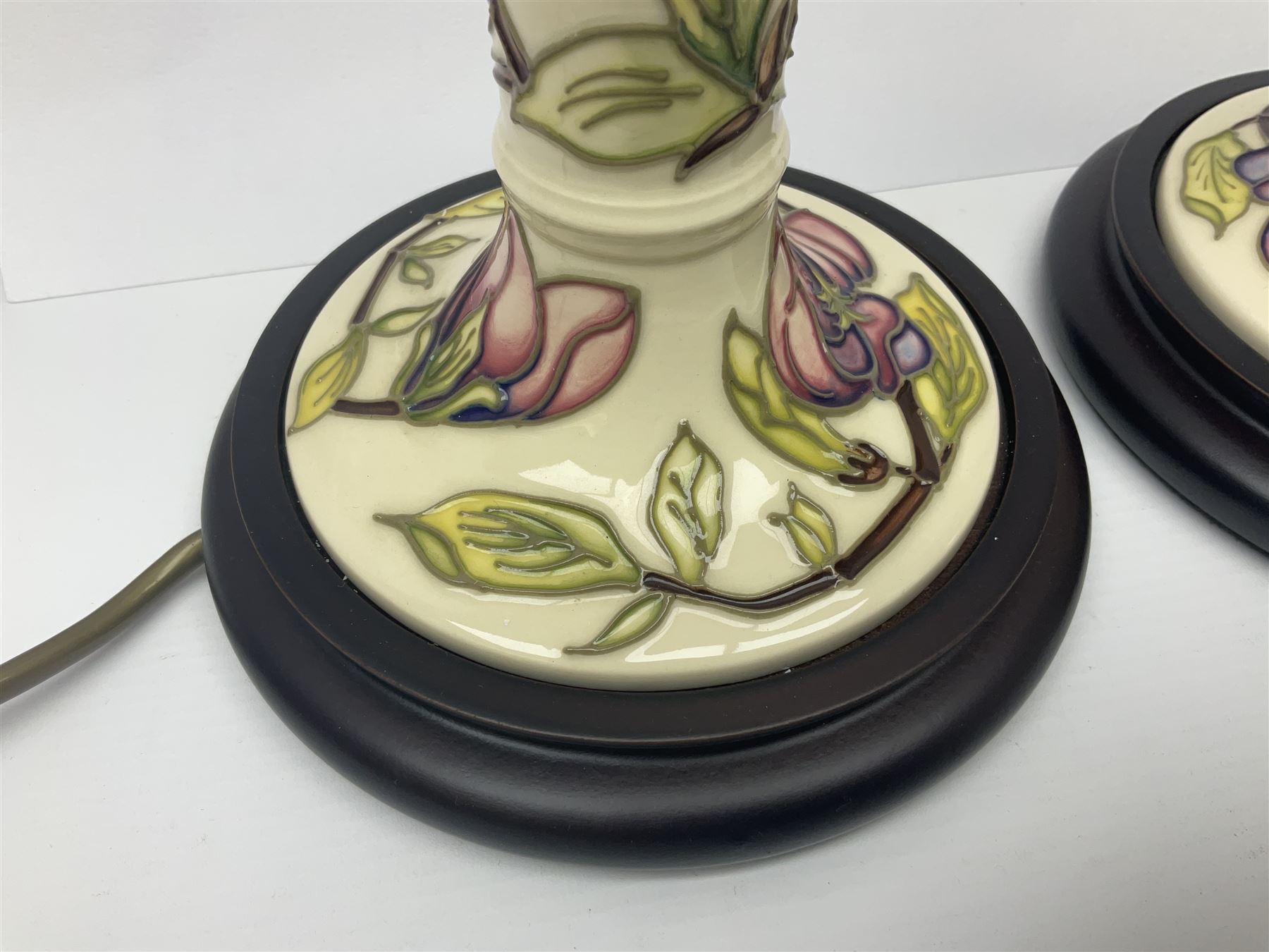 Pair of Moorcroft table lamps of candlestick form in magnolia pattern, with Moorcroft shades, H50cm 
