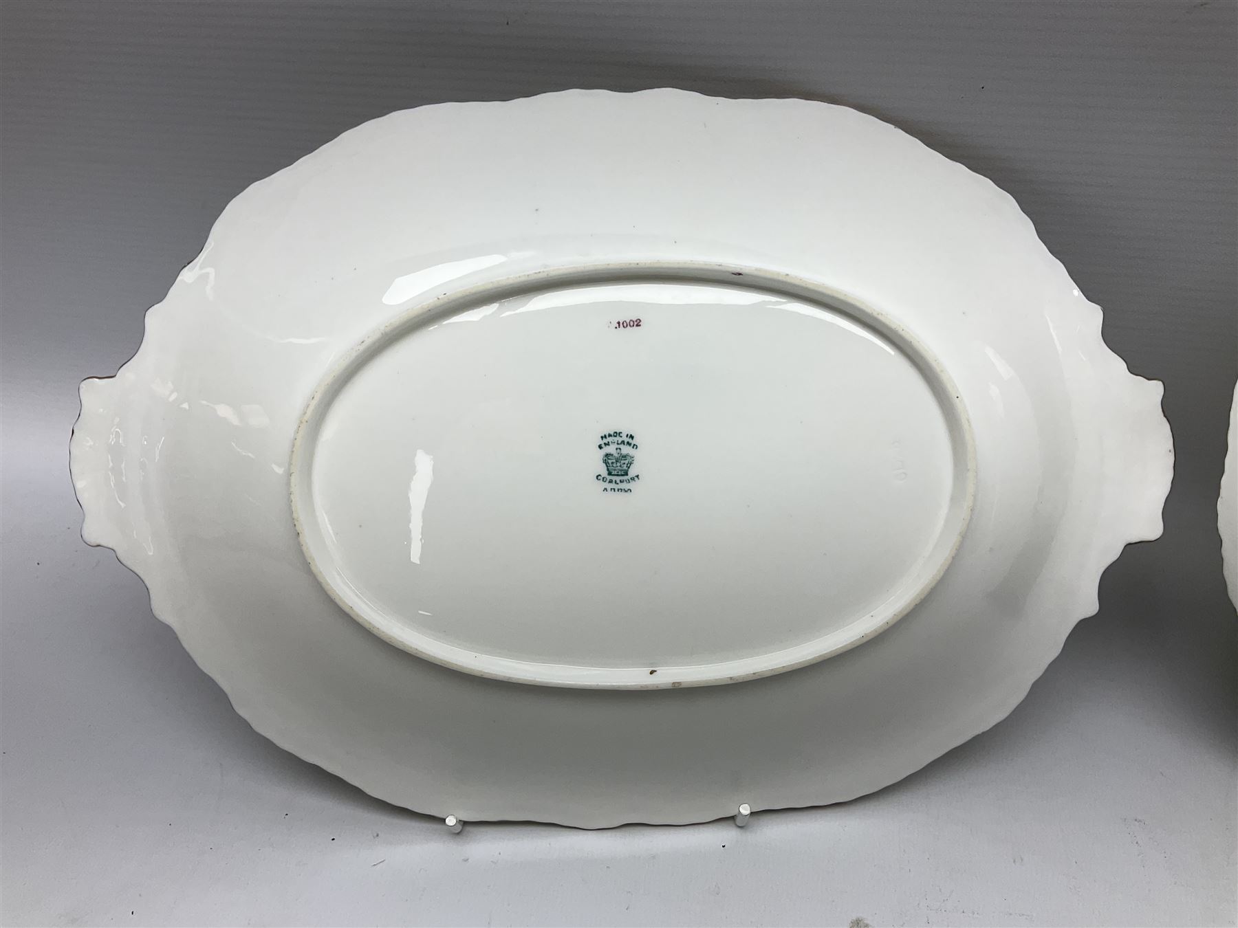 Coalport green batwing pattern tea wares, decorated with finely enamelled floral sprays within gilt reserves, comprising teacup trio, twin handled cake plate and side plate, pattern no Y2665, together with a Coalport for Harrods cup and saucer similarly decorated, the saucer with stamped mark beneath 'Manufactured for Harrods Ltd, Brompton Rd London', all with green Coalport AD 1750 marks beneath, largest W31cm (7)