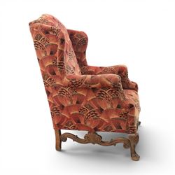 Large upholstered wingback chair, crimson geometric upholstery, carved front apron raised on cabriole supports 