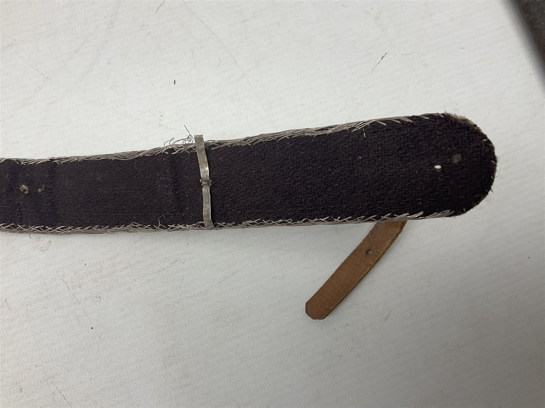 Omani Khanjar dagger, the 19cm curved blade with pronounced medial rib to either side, waisted hilt with dome shaped pommel and silver covered horn grip decorated with filigree bands, floral motifs and beadwork; in an intricately filigree decorated silver and leather scabbard with silver rings woven into the belt mount and fitted with original silver thread-work belt L34cm overall belt length 94cm