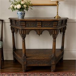 Jacobean design carved oak side or credence table, demi-heptagon top with moulded edge, fr...
