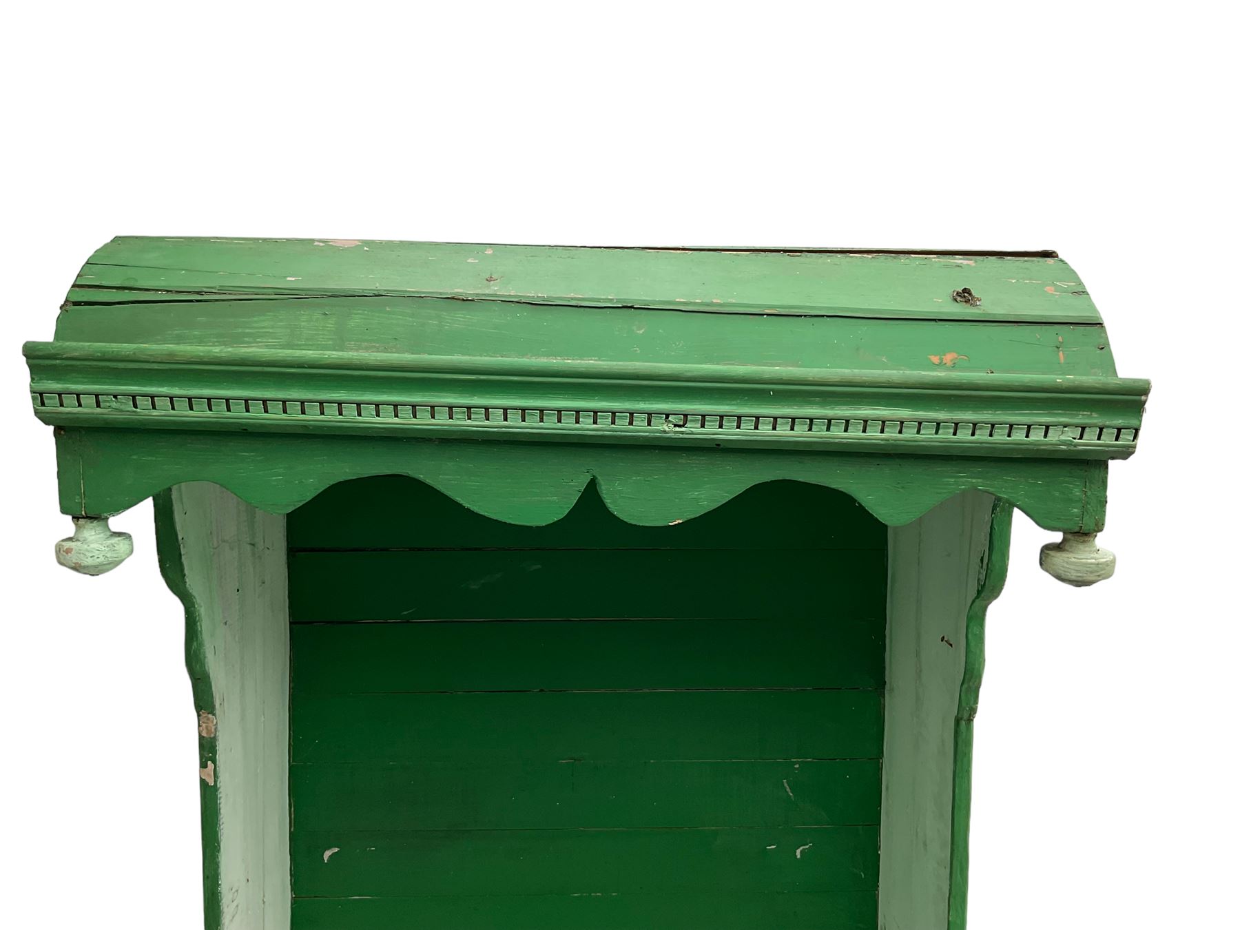 19th century painted pine hen coop settle, overhanging arched canape with dentil moulding and shaped edge, the panelled seat over a triangular platform base with removable hen-coop door, in green and white finish
