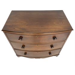Small early 19th century figured walnut bow front chest, fitted with three graduating drawers with turned handles, with shaped apron and bracket feet