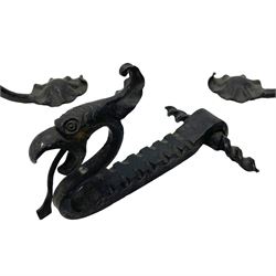 Wrought metal firedogs or andirons, in the form of winged dragons with gaping jaws and projecting tongues, scrolled rear support and extending shaped pad feet; together with matching fireside tongs, poker and tool rest 
