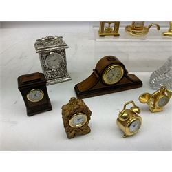 Collection of miniature clocks, predominantly with quartz movements, to include example modelled as an armchair, Edinburgh crystal glass example, clock modelled as a flower, sewing machine etc