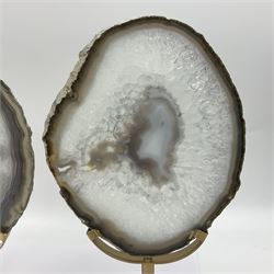 Pair of white agate slices, polished with rough edges raised upon gilt metal stands, H24cm