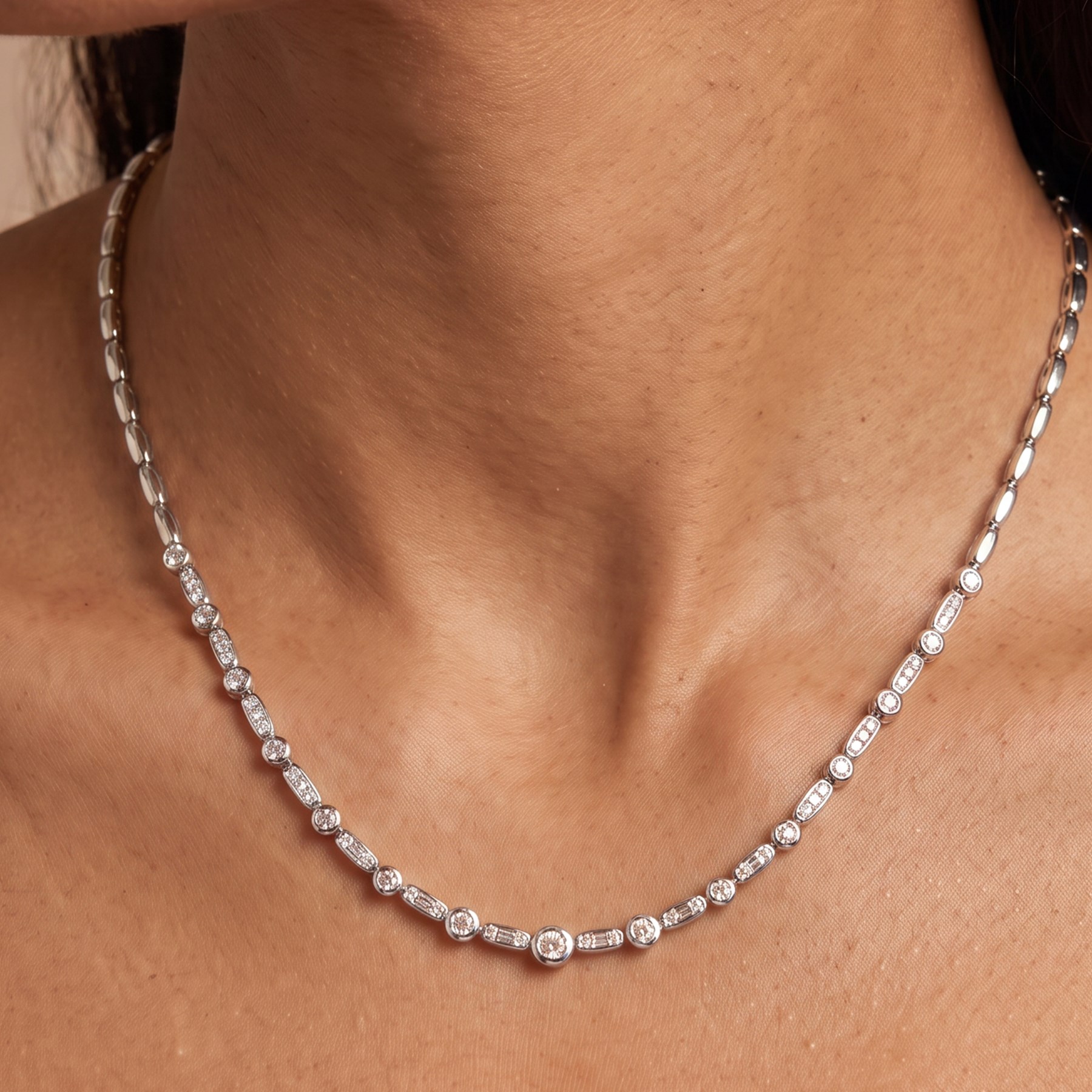 18ct white gold diamond necklace, bezel set with a single round brilliant cut diamond, spaced by two further diamonds, to a rectangular link necklace, London 2000, total diamond weight approx 0.75 carat