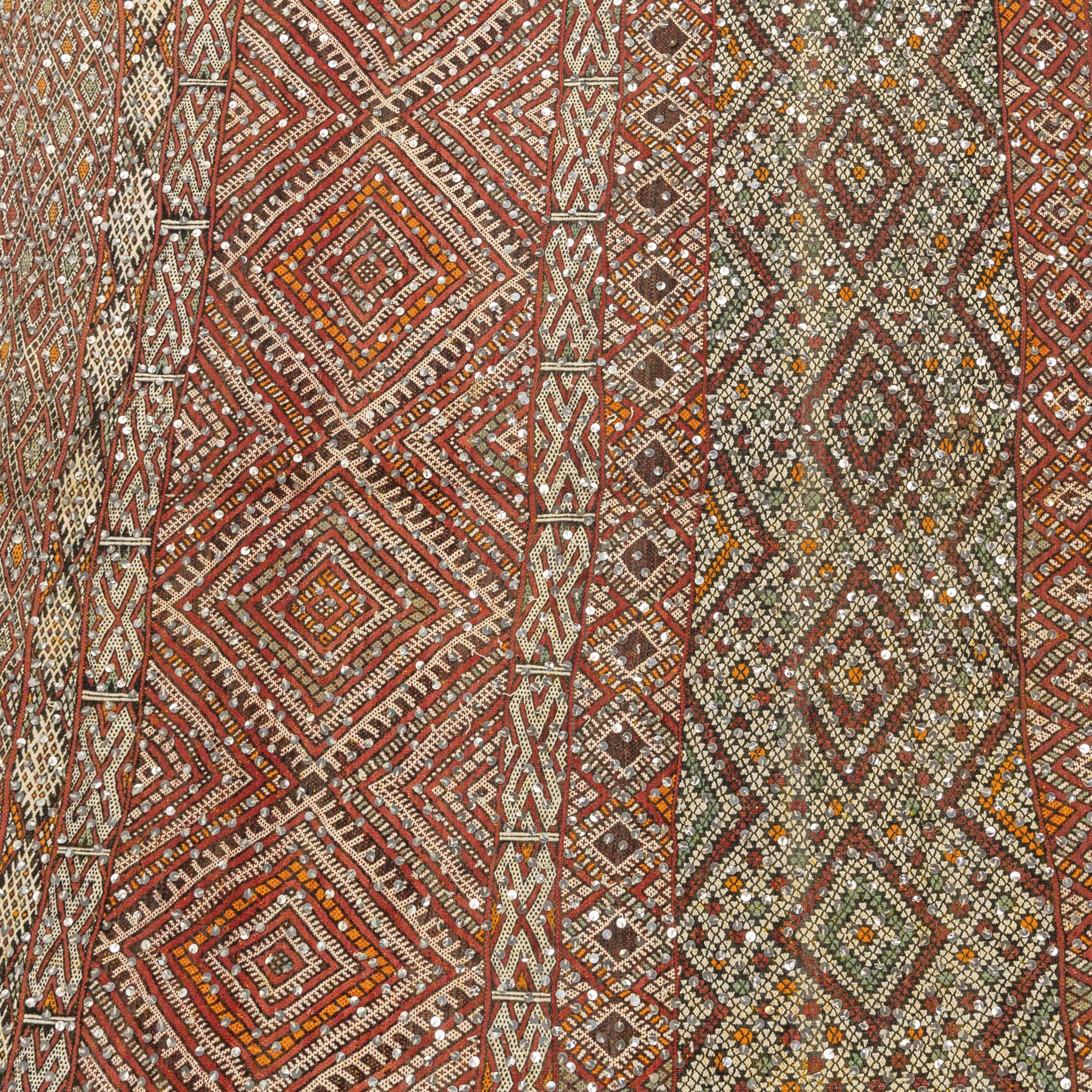 Moroccan Berber kilim rug, flatwoven with bands of geometric lozenge and chevron motifs in red, orange, ivory and green, decorated with applied sequins, fringed ends