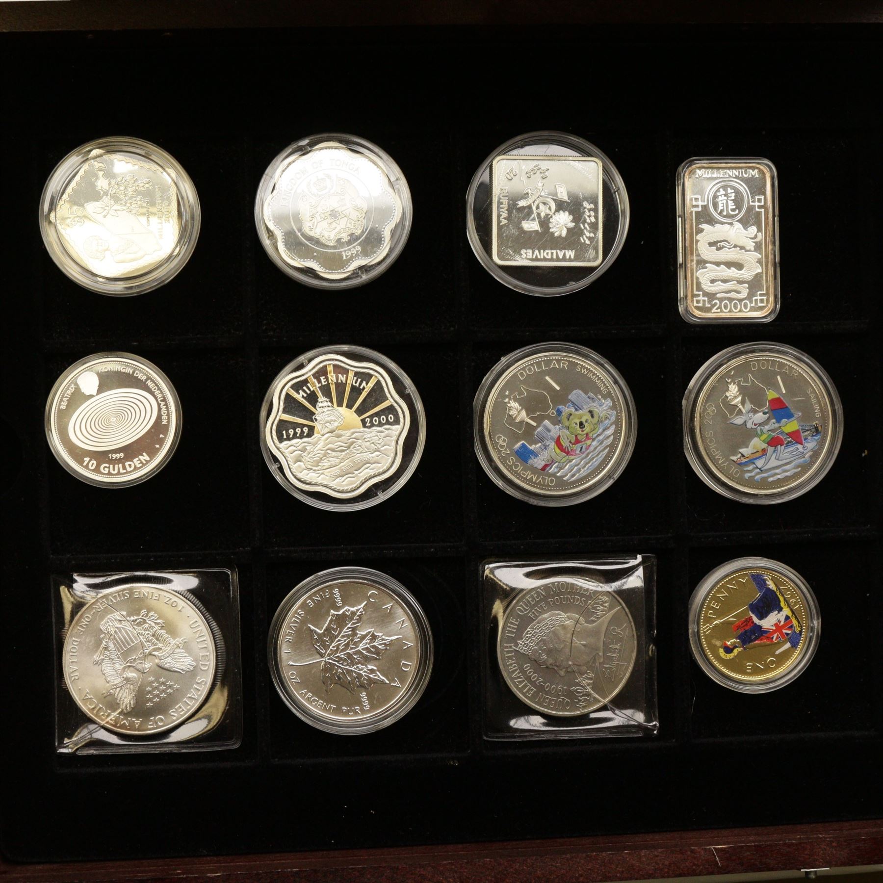 Mostly commemorative coinage, including various Queen Elizabeth II crowns, The Royal Mint United Kingdom 1999 silver proof five pounds, Canada 1999 one ounce fine sliver five dollars, Bermuda 2000 two dollars, Guyana 2000 two-thousand dollars, New Zealand 2000 ten dollars etc, housed in a coin display case and loose