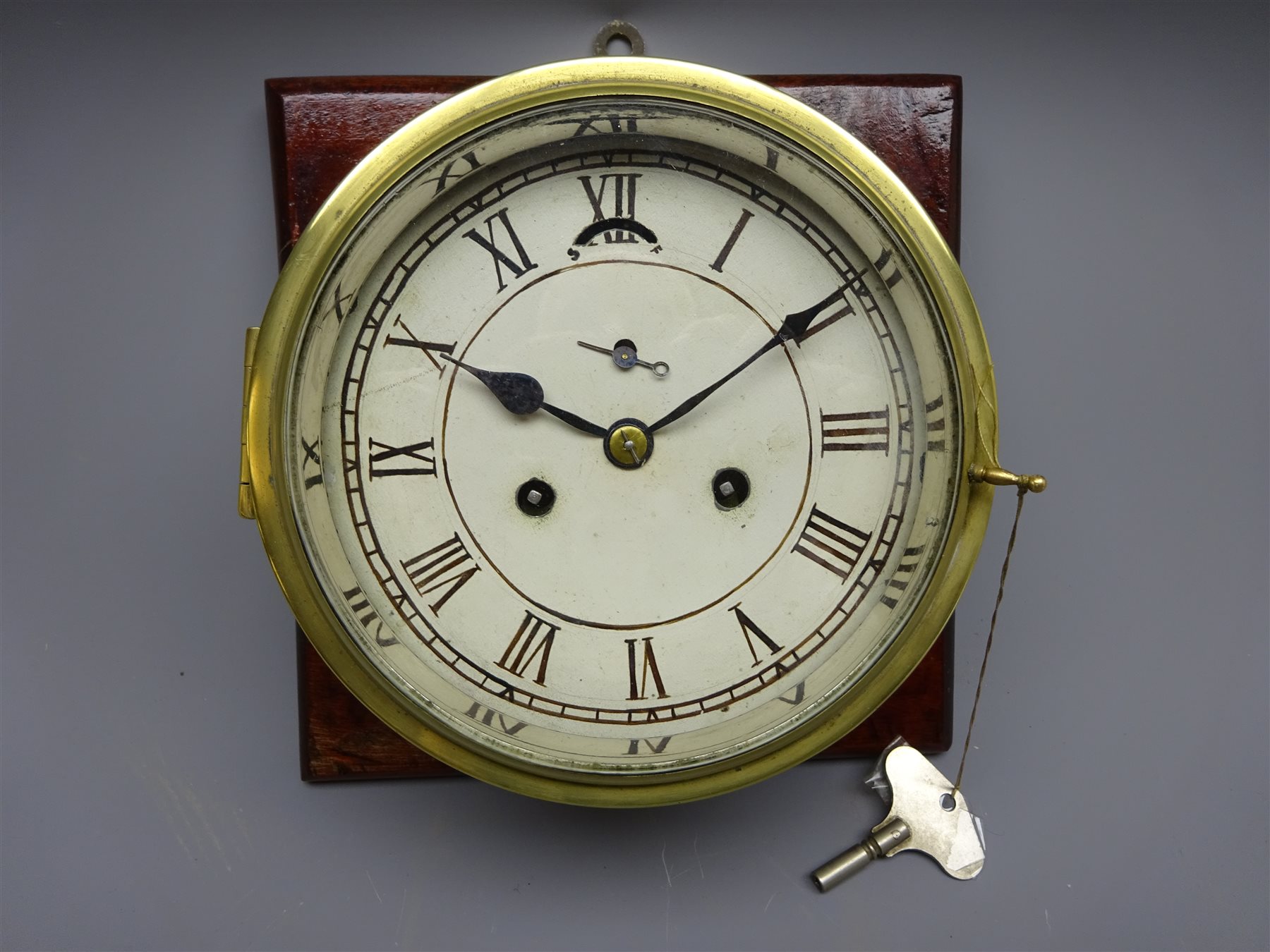Brass bulkhead clock, painted Roman dial with subsidiary seconds and