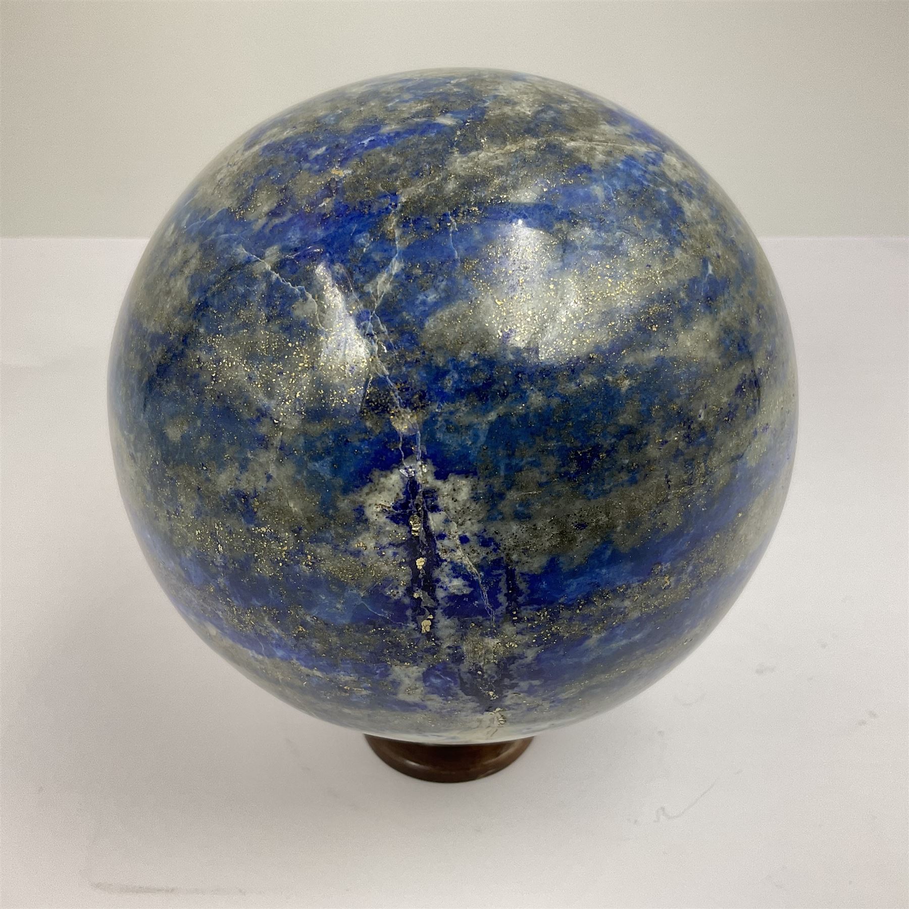 Lapis lazuli sphere upon a carved wooden base 