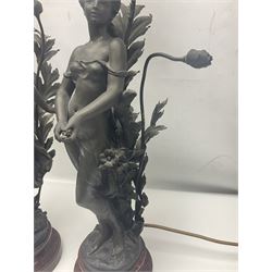 Pair of Art Nouveau style spelter figural table lamps, each mounted on rouge marble effect circular bases, with toleware flower heads and leafy decoration surrounding a female figure, H90cm