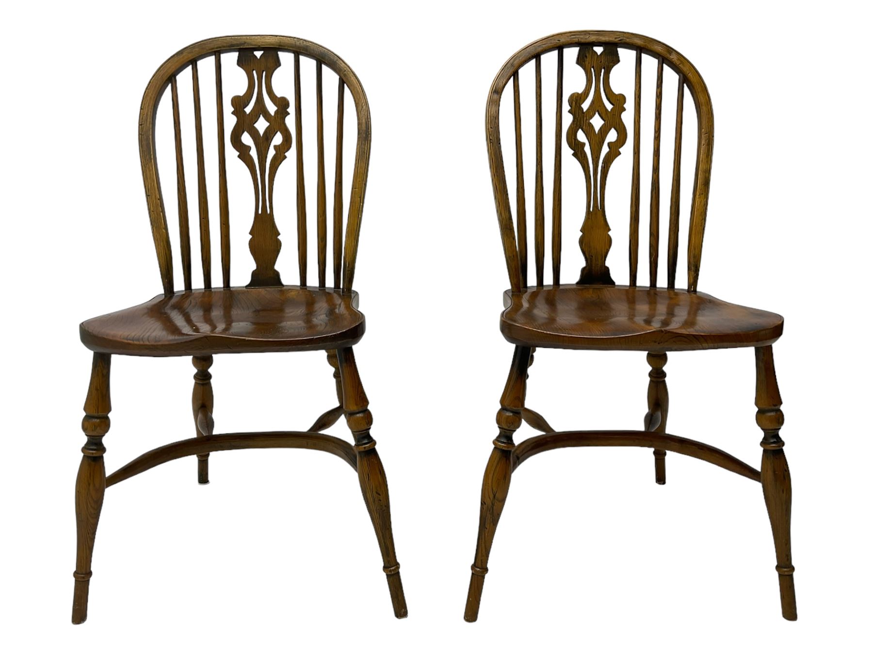 Set of four elm Windsor dining chairs, high hoop and stick back with shaped pierced splat, over shaped saddle seat, raised on ring turned supports joined by crinoline stretcher