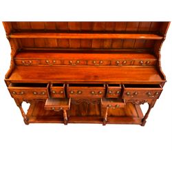 George III design cherry wood dresser, the projecting cornice over shaped frieze with pierced shell decoration, fitted with three shelves over six spice drawers, the base fitted with three long and two short drawers with cock-beaded facias, shaped and pierced apron over turned supports and panelled pot board base 