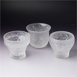 Three Lalique frosted glass tea light holders, decorated with the coriander and basil patt...