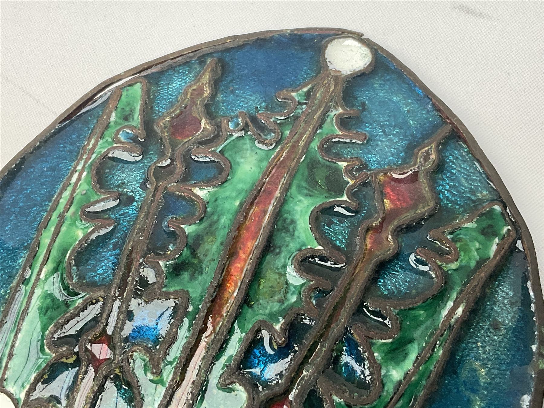 Henry George Murphy (1884-1939), Arts & Crafts enamel panel, of bulbous elliptical form decorated with a stylised crown in green, red and white, upon a turquoise toned ground, H12cm W9cm