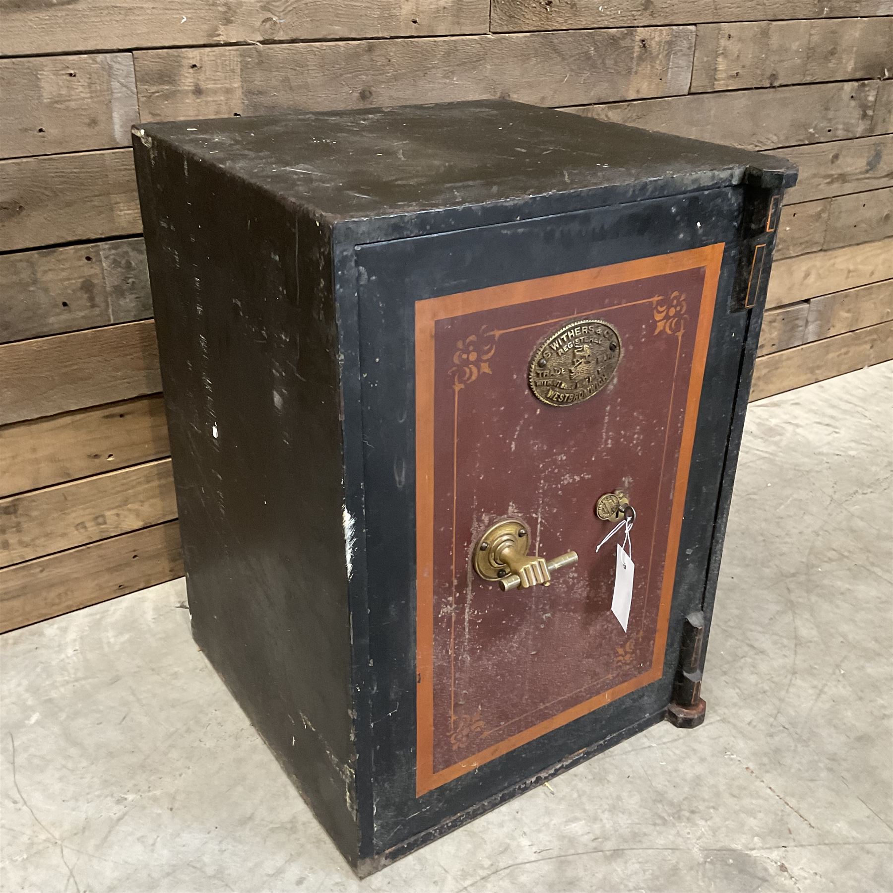 Samuel Withers & Co of West Bromwich - Victorian cast iron safe, the brass handle modelled as a clenched fist, painted in red, orange and black, with key. Ground floor delivery only, no steps.