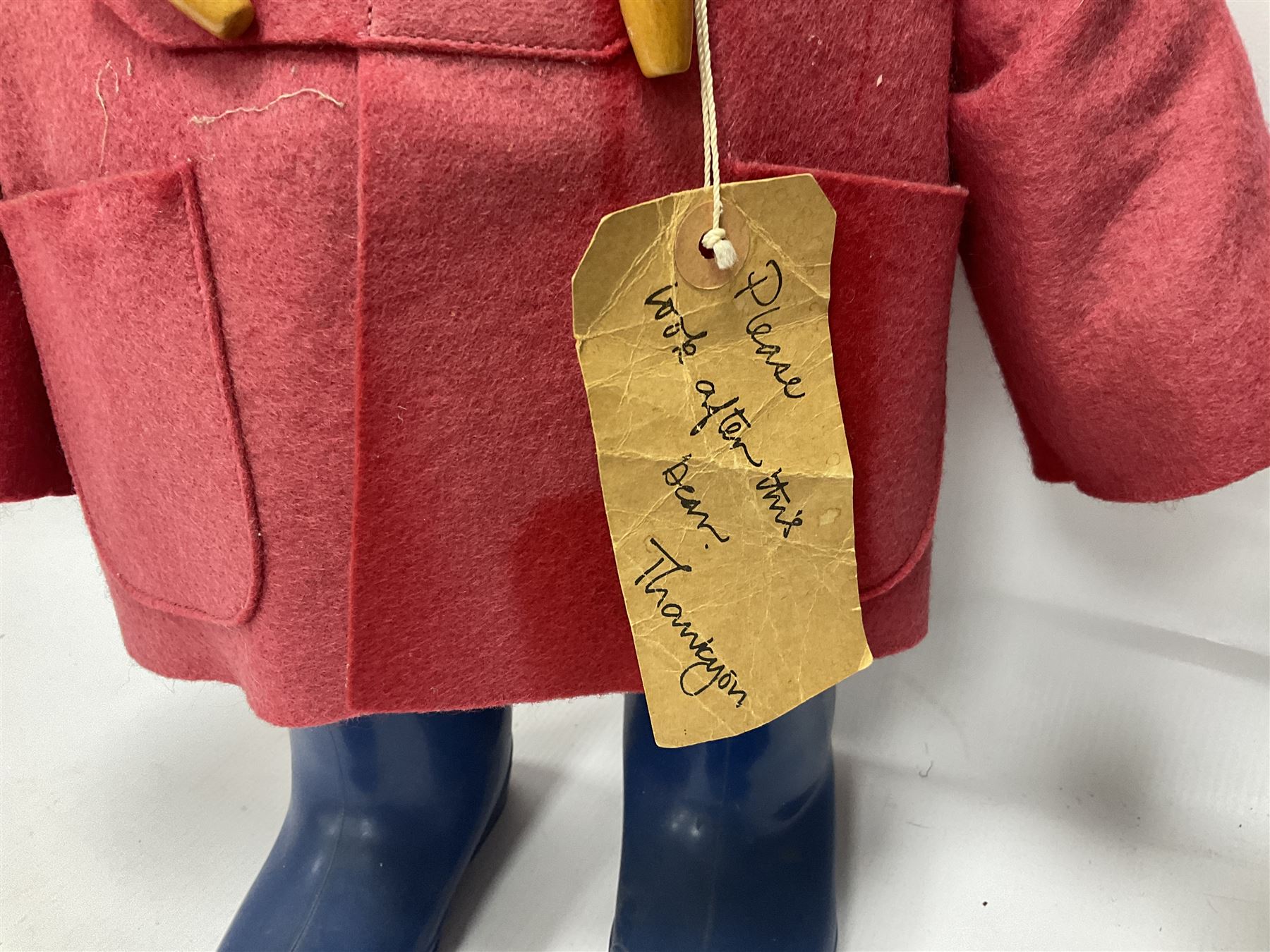 Pair of Paddington Bear teddies with amber eyes, the first example having a brown felt hat, red coat and blue PB boots with original label; the second having a grey felt hat, blue coat and blue Dunlop boots, tallest H51cm 