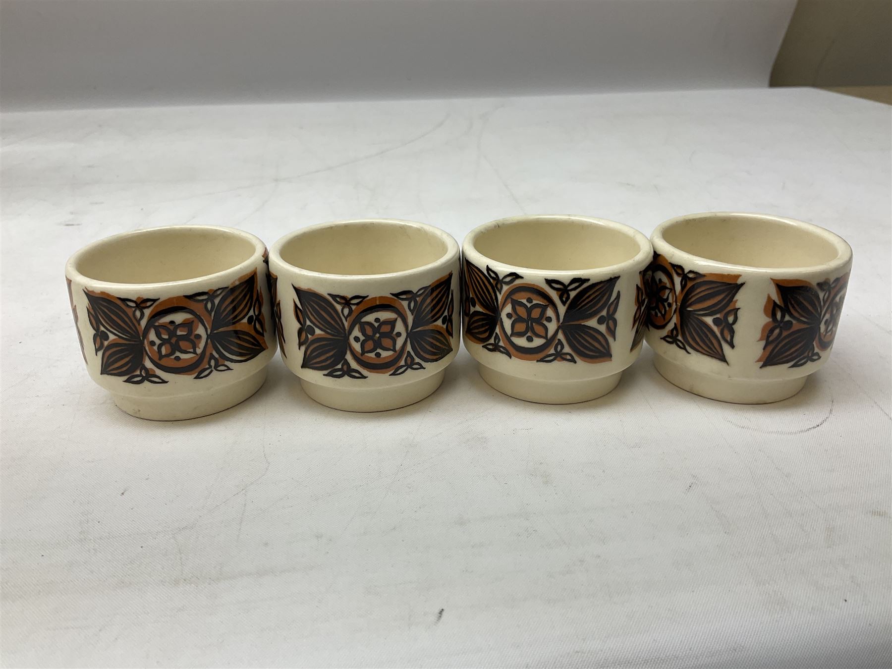 Collection of 1970s Hornsea mugs designed by John Clappison, comprising six Train Robber pattern examples together with owl patterned example on dark teal ground, and further example decorated with stylised hen and chick and egg, approx 9cm, together with four small cup bowls, all with stamped Hornsea marks beneath