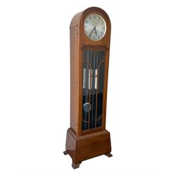 English- Art deco mahogany 8-day longcase clock, with an arched top and fill length fully glazed door beneath, on a short plinth with bracket feet, three train chain driven movement with visible stainless steel cased weights and pendulum, silvered dial with Arabic numerals, minute track and pierced steel hands, quarter chiming movement with  Westminster/ Whittington/ strike/silent selection.
