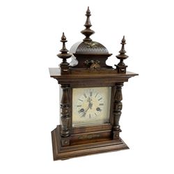Juhngans -  8-day oak cased mantle clock c1910, with a carved ogee pediment and turned finials, turned half-columns to the dial, on a broad plinth with bun feet, square etched dial with Roman numerals and pierced hands, striking movement, striking the hours and half hours on a coiled gong. With key and pendulum.   