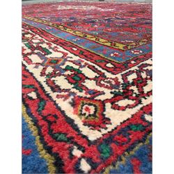 Northwestern Persian Hamadan hand-knotted rug, madder red field with a lozenge medallion enclosing an ivory centrepiece, indigo spandrels within an ivory border of stylized floral motifs between multiple guard borders 