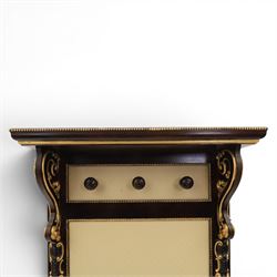 Empire design ebonised and parcel gilt hall stand, projecting moulded cornice with bead and reel border, upper rail fitted with three turned hat and coat pegs, central cream upholstered panel within beaded slip, flanked by scrolled uprights with gilt foliate and anthemion mounts, lower acanthus leaf apron, on paw feet